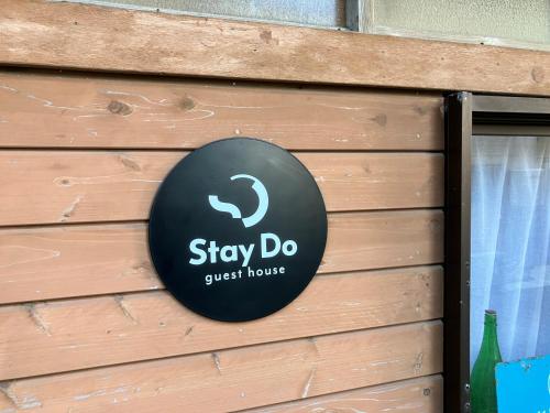 a sign that says stay do guest house on a wall at Stay Do in Oshima