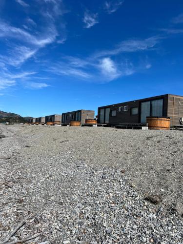 a group of buildings on a gravel field at Chelenko Lodge in Puerto Tranquilo