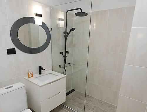 a bathroom with a shower and a sink and a mirror at Location Location Executive Apartment in Sydney