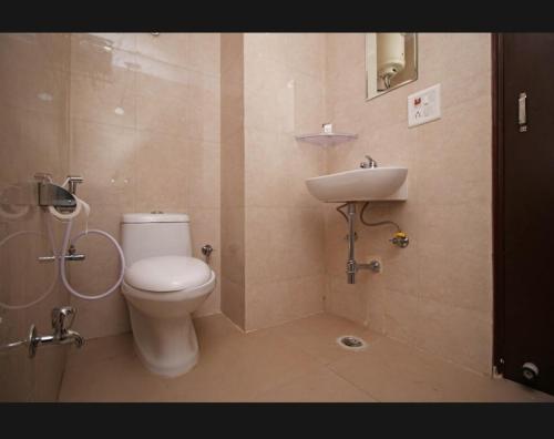 a bathroom with a toilet and a sink at Surya Stay Inn in New Delhi
