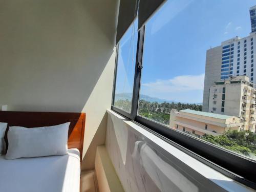 1 dormitorio con cama y ventana grande en Senkotel Nha Trang Managed by NEST Group en Nha Trang