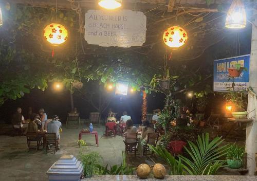 een groep mensen die 's nachts in een restaurant zitten bij Hai Long homestay in Hội An