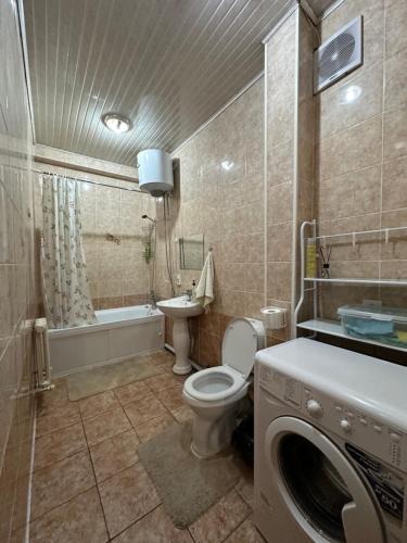 y baño con aseo, lavabo y lavadora. en 1-room apart. 21 on Usenbaeva 52 near Eurasia shopping center, en Bishkek