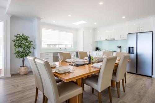 a kitchen and dining room with a wooden table and chairs at Seaside Serenity Jervis Bay in Huskisson