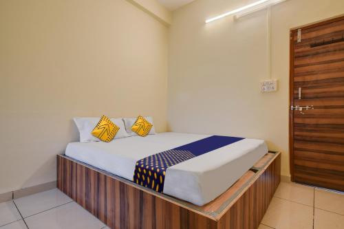 Un dormitorio con una cama con almohadas amarillas y azules. en OYO Hotel Shivaj, en Indore