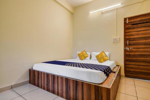 1 dormitorio con 1 cama con almohadas amarillas y azules en OYO Hotel Shivaj, en Indore