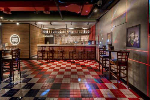 a bar with chairs and a checkered floor at Wescott Hotel in Dubai
