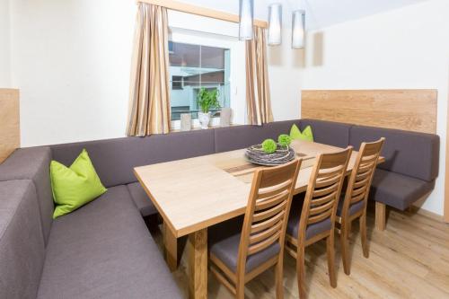 uma sala de jantar com uma mesa e um sofá em Alpinhome em Tux