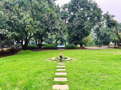 a garden with a stone path in the grass at NB Nature Stay in Navi Mumbai
