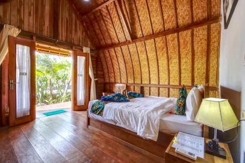 a bedroom with a bed in a room with a window at Kira Cottages in Nusa Penida