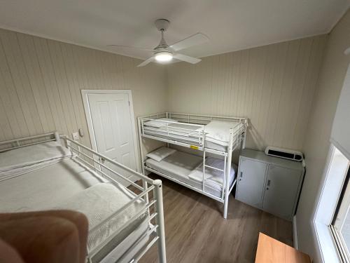 a room with two bunk beds and a ceiling fan at Charming 3 bedroom Workers Accommodation in Grafton