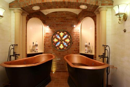 - 2 baignoires dans une salle de bains avec un mur en briques dans l'établissement Nesselbeck, à Orlovka