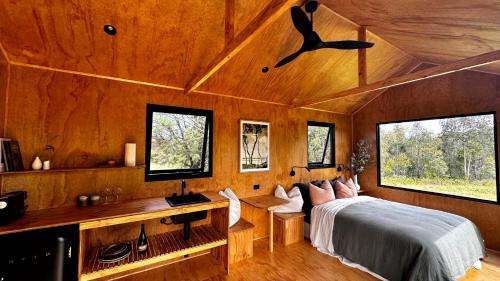 1 dormitorio con 1 cama, escritorio y ventanas en Omeo Holiday Park, en Omeo