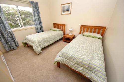 two twin beds in a room with a window at Seabreeze 3 at South West Rocks - No Sheets or Towels Provided in South West Rocks