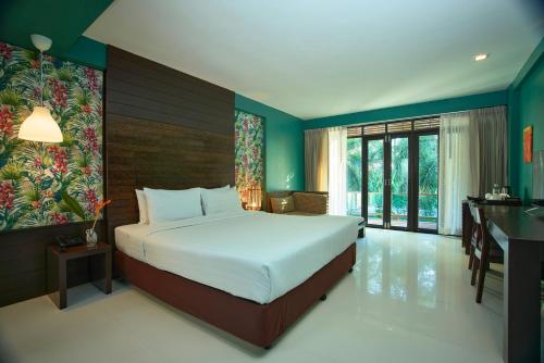 a bedroom with a large bed and a desk at The Bihai Hua Hin in Hua Hin