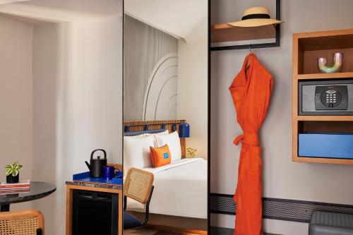 a room with a bed and a desk with a hat at Hyatt Ronil Goa - a JdV by Hyatt Hotel in Calangute