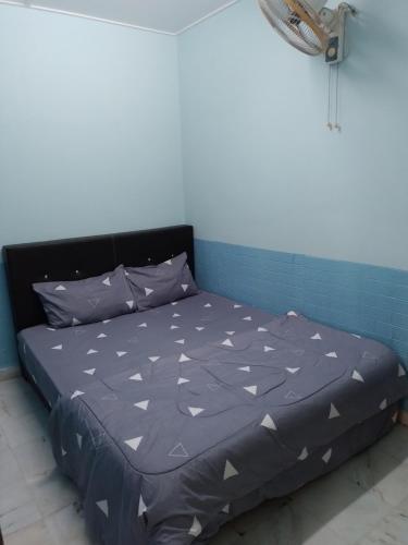 una cama en una habitación con una pared azul en Rent Room, en Ipoh
