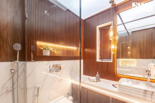 a bathroom with a tub and a sink and a mirror at StayVista's House Of J - Embrace Leisure with Lawn, Pool, and Gazebo in Lonavala