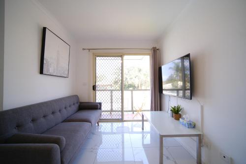 a living room with a couch and a table at Golf Place Inn Wollongong in Wollongong