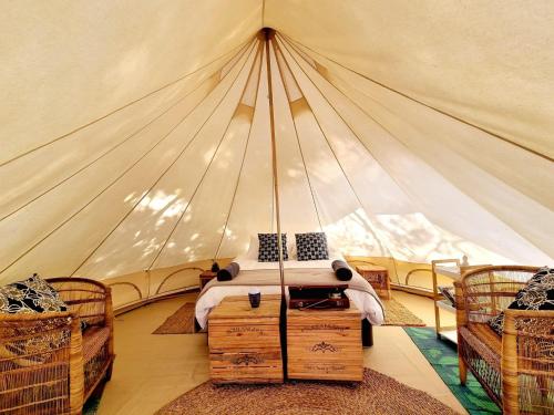 a bedroom with a tent with a bed in it at Zen Valley Glamping in Plettenberg Bay