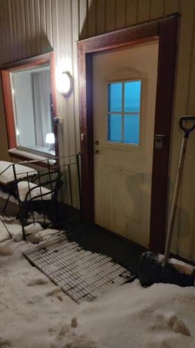 drzwi w pokoju ze śniegiem na podłodze w obiekcie Vojengården Lägenhet 3 w mieście Ånge