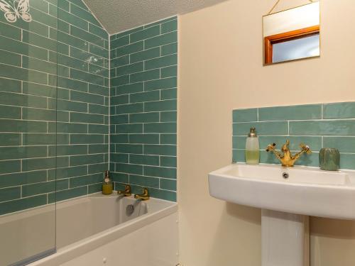 a bathroom with a sink and a bath tub at 3 Bed in South Molton 78304 in Kings Nympton