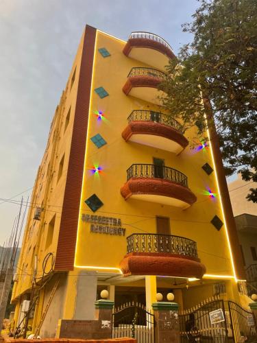 a yellow building with balconies on the side of it at JK Home Stay in Tirupati