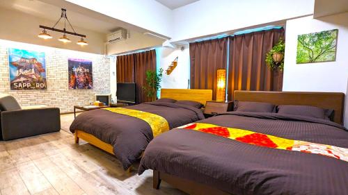 a bedroom with two beds and a television in it at KIYAZA Station Sapporo 2 in Sapporo