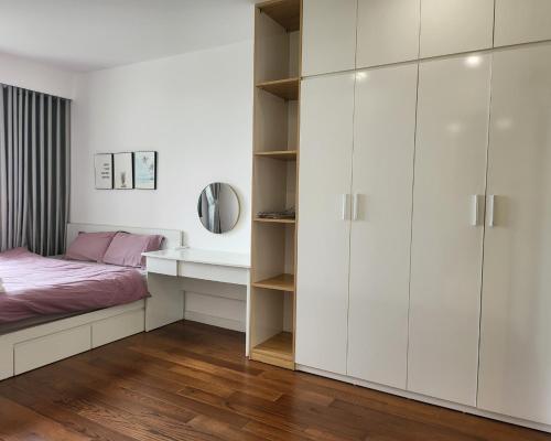 um quarto com armários brancos, uma cama e uma secretária em 2 BR Vinhomes Dcapitale next to Charmvit Tower em Hanói