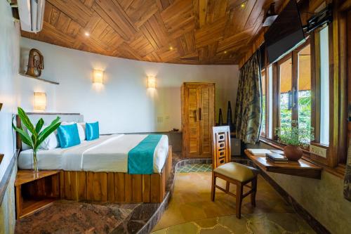 1 dormitorio con 1 cama y escritorio en una habitación en ama Stays & Trails Eden Farms Emerald , Goa, en Goa