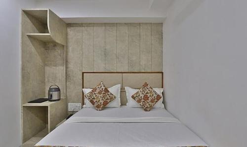 um quarto com uma cama com almofadas em FabHotel Prime Legend em Surat
