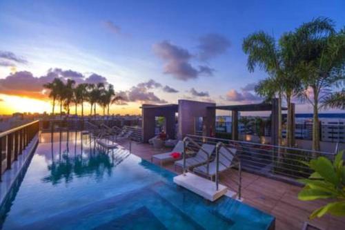 ein Haus mit einem Pool mit Sonnenuntergang in der Unterkunft O melhor de Maceió, Edf Time, Ponta verde. in Maceió