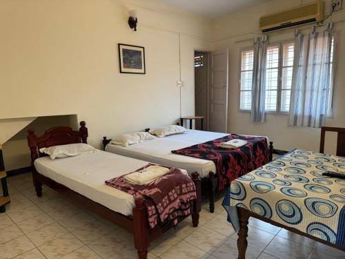 a room with two beds and two tables sidx sidx sidx at Aambal Residency in Cochin