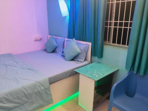 um pequeno quarto com uma cama e uma mesa em Greenland gokarna Ac and Non Ac em Gokarna