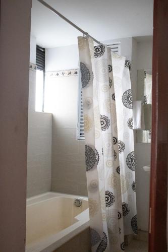 a bathroom with a tub and a shower curtain at Hotel El Castillo Chinauta in Chinauta