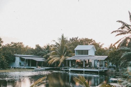 a house on a dock next to a body of water at Matchoon Homestay in Ban Noen Klang