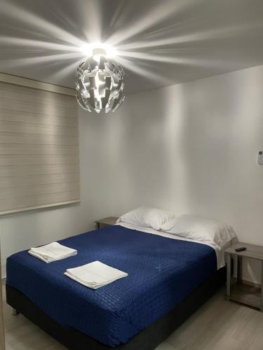 a bedroom with a blue bed with a light above it at Apartamento Girardot Peñalisa con Piscina in Ricaurte