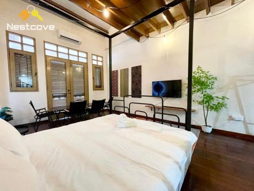 a bedroom with a bed and a table and chairs at SOINN Jonker Guesthouse By Nestcove in Melaka