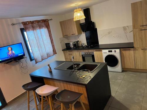 a kitchen with a sink and a counter with stools at KOM LA KAZ in Cilaos