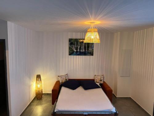 - une chambre avec un lit et un lustre dans l'établissement KOM LA KAZ, à Cilaos