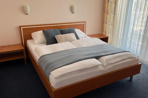 Una cama en una habitación de hotel con almohadas. en Hotel Imperium en Moravske-Toplice