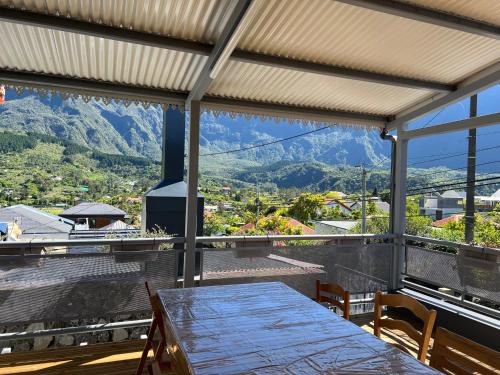 - une salle à manger avec une table et une vue sur les montagnes dans l'établissement KOM LA KAZ, à Cilaos