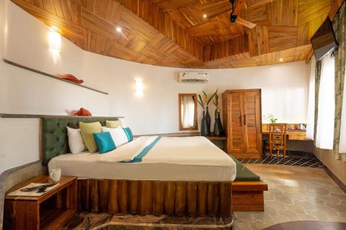 1 dormitorio con cama y techo de madera en ama Stays & Trails Eden Farms Aqua Marine , Goa, en Goa