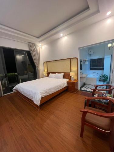 a bedroom with a large white bed and a desk at Cao Son Hotel in Bắc Quang