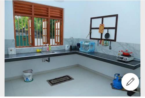 encimera de cocina con fregadero y ventana en Sanasuma Villa, en Bentota
