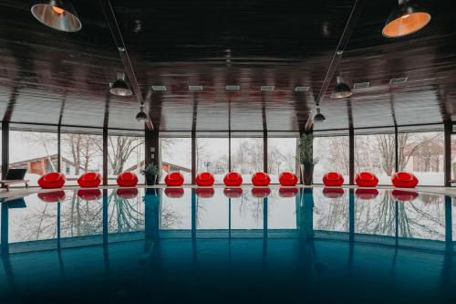 a group of red chairs in a room with snow at Marco Polo Hotel Gudauri in Gudauri