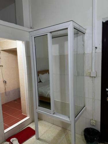 um armário de vidro num quarto com uma cama em Everest Restaurant and Guest House em Sihanoukville