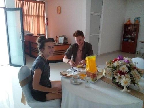 un hombre y una mujer sentados en una mesa en Vintop Hotel & Homestays Gampaha, en Gampaha