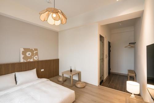a bedroom with a bed and a chandelier at Chunns Inn in Hengchun