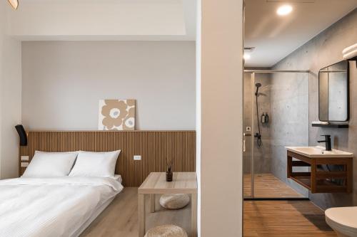 1 dormitorio con 1 cama y baño con ducha en Chunns Inn, en Hengchun
